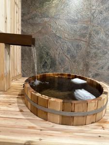 bañera de madera con fuente de agua en Luxury suite with Sauna and Spa Bath, Dogs Welcome - Elkside Hideout, en Canmore