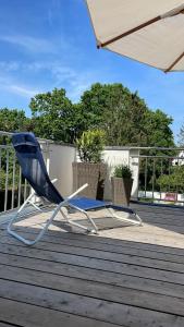 una silla azul sentada en una terraza con sombrilla en City Wohnung mit Gartenblick und Dachterrasse, en Verden