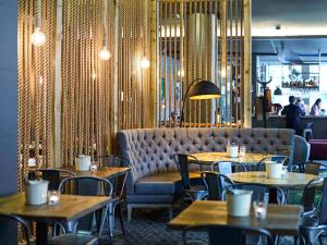 un ristorante con tavoli, sedie e un divano di Novotel Liverpool Centre a Liverpool