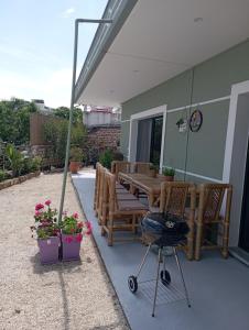 un patio avec une table, des chaises et un grill dans l'établissement Xhorxhi villa, à Ksamil