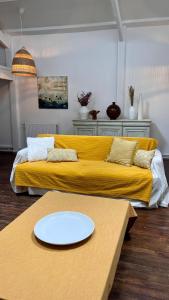 uma sala de estar com um sofá amarelo e uma mesa em Artist's Home - Villa & Private Courtyard - 200m2 em Paris