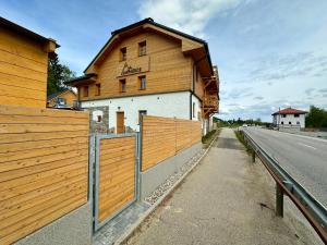 een gebouw met een houten hek naast een weg bij Apartmán Na Hůrce in Horní Planá