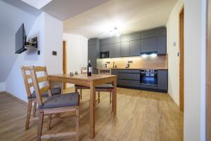 een keuken en eetkamer met een houten tafel en stoelen bij Apartmán Na Hůrce in Horní Planá