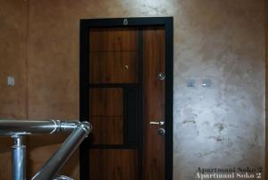 a wooden door in a room with a stone wall at Apartman Soko 2 in Soko Banja