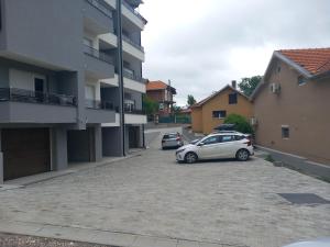 two cars parked in a parking lot next to a building at Apartman Soko 2 in Soko Banja