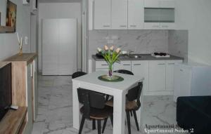 a kitchen with a table with a vase of flowers on it at Apartman Soko 2 in Soko Banja