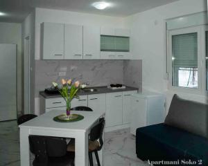 a kitchen with a table with a vase of flowers on it at Apartman Soko 2 in Soko Banja