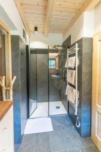 a bathroom with a shower and a glass shower stall at ALPIK Chalets - Bohinj in Bohinj