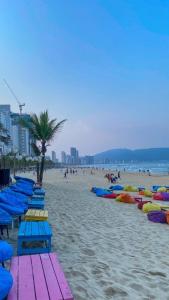 una playa con sillas de playa coloridas y gente en ella en Lucia Beach Hotel, en Da Nang