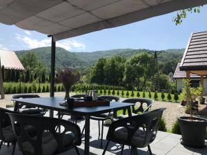 a blue table and chairs on a patio with a view at Domek szeregowy nr 2 in Tylmanowa