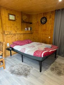 a bed in a room with a wooden wall at Apparemment cosy style savoyard in Bourg-Saint-Maurice