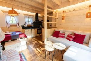 a living room with a white couch and red pillows at ALPIK Chalets - Bohinj in Bohinj