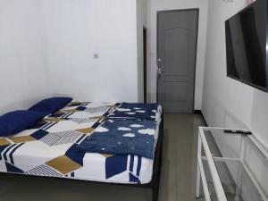 1 dormitorio con 1 cama, TV y puerta en Hotel Residence 5 Syariah, en Bandung