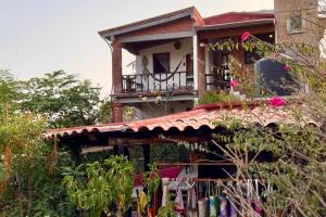 een huis met een balkon er bovenop bij Casa Azar in Mazunte