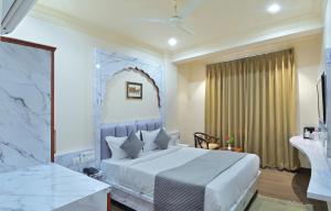 a bedroom with a large white bed and a desk at Trim Boutique Parkota Haveli in Jaipur