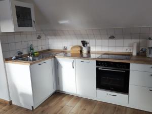 una cucina con armadi bianchi e lavandino di Ferienwohnung Arff a Rendsburg