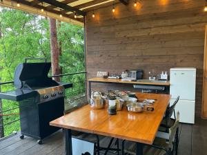 uma cozinha com uma mesa de madeira e um fogão em Retreat Camp Mahoroba em Fujikawaguchiko