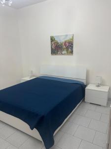 una camera con letto blu e due comodini di Villa Maccioni a Budoni