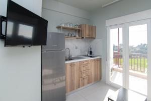 a kitchen with a stainless steel refrigerator and a balcony at Olea Apartments Palioura Epanomi in Epanomi