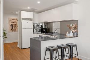 cocina con encimera con taburetes y nevera en Lifestyle Location - WIFI Included, en Newcastle