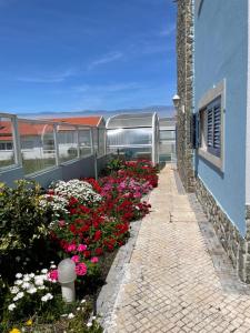 un jardin de fleurs à côté d'un bâtiment dans l'établissement Villa da Praia, à Sintra