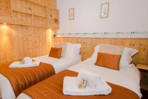 twee bedden in een kamer met houten wanden bij Rond Point d Arbois in Megève