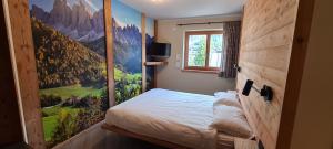 a bedroom with a mountain mural on the wall at Appartamenti Home Service in Arabba