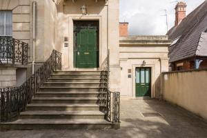 uma porta verde no lado de um edifício com escadas em Judges Lodgings Hotel Apartments Gloucester Docks with Secure Parking em Gloucester