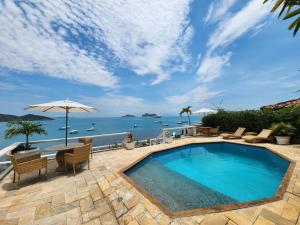 a swimming pool with a view of the ocean at Byblos Pousada in Búzios