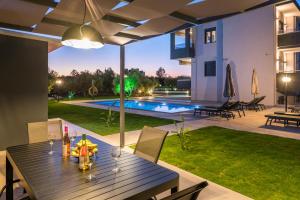 una mesa de comedor en el patio trasero de una casa en Aspect Luxury Apartments with Pool, en Galangádhos