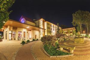 a building with a courtyard at night at Malinowy Dwór Hotel Medical SPA in Świeradów-Zdrój