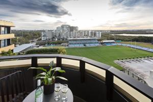 uma varanda com uma mesa com copos de vinho e um campo de basebol em Quest Woolooware Bay em Cronulla