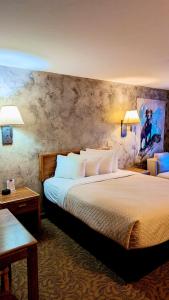 a hotel room with a large bed and two lamps at Browns Canyon Inn in Salida