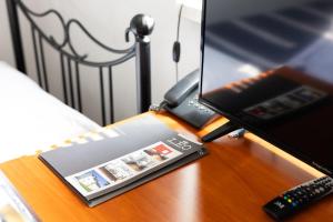 a book on a table next to a computer monitor at Leo Hostel in Poznań