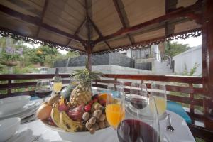 uma mesa com uma taça de fruta e copos de vinho em Royal Majestic Grand Thai Villa em Choeng Mon Beach