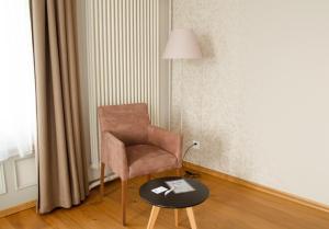 une chaise et une table dans une pièce avec une lampe dans l'établissement Concept Hotel Landhaus, à Burgdorf