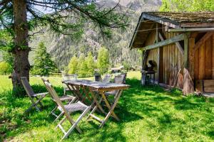 einen Tisch und Stühle im Gras neben einer Hütte in der Unterkunft Chalet Taconnaz - Warm & Cosy 3BR Chalet with Fireplace in Nature - By Cozee Rentals in Les Houches