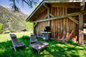 eine Hütte mit 2 Stühlen, einem Tisch und einem Herd in der Unterkunft Chalet Taconnaz - Warm & Cosy 3BR Chalet with Fireplace in Nature - By Cozee Rentals in Les Houches