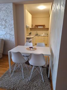 a white table and chairs in a small kitchen at SAN in Čačak