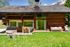 eine Blockhütte mit einer Veranda und einem Schlafzimmer in der Unterkunft Chalet Taconnaz - Warm & Cosy 3BR Chalet with Fireplace in Nature - By Cozee Rentals in Les Houches