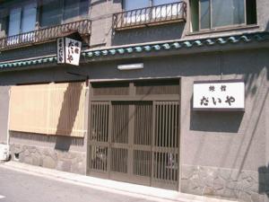 un edificio con una porta e un cartello sopra di Daiya Ryokan a Kyoto