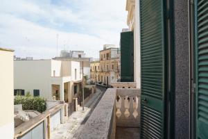 einen Balkon mit Blick auf eine Straße mit Gebäuden in der Unterkunft RUDIAE Palace In Lecce in Lecce