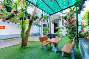 een patio met een tafel, banken en planten bij Villa Hồ Bơi Karaoke - Bida - Sân Vườn - Gần Biển Thùy Vân in Vung Tau