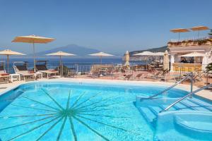 uma grande piscina com cadeiras e guarda-sóis em Grand Hotel de la Ville em Sorrento