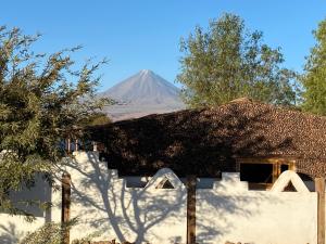 Cabañas Voyage Atacama في سان بيدرو دي أتاكاما: جبل في البعد خلف المنزل