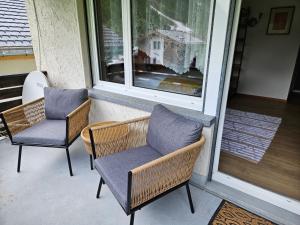 twee stoelen en een raam op een veranda bij Apartment Klein Matterhorn - Haus Miranda in Täsch