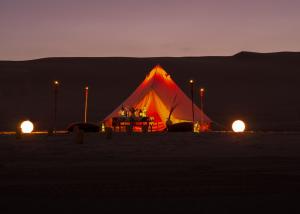 una tienda roja en el desierto por la noche en Duna Camp Huacachina, en Ica