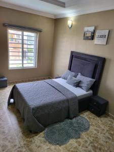 Schlafzimmer mit einem großen Bett und einem Fenster in der Unterkunft Dvyne Lux Home - Off Ikeja in Ikeja