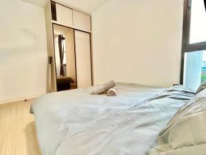 ein weißes Bett in einem Zimmer mit einem großen Fenster in der Unterkunft Cozy Place 1-8 Pax 3 bedroom Ara Damansara in Petaling Jaya