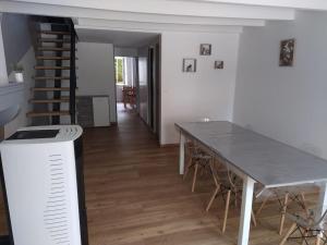 une salle à manger avec une table et un escalier dans l'établissement Gîte des deux petits doudous, à Colombey-les-Deux-Églises